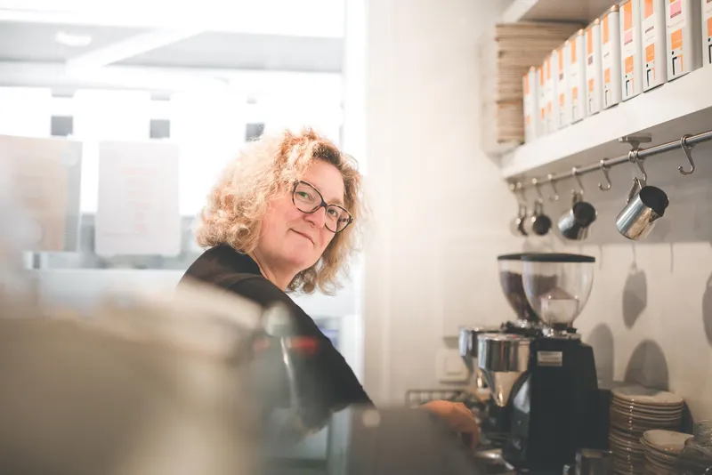 Christel aan de koffiemachine in de winkel