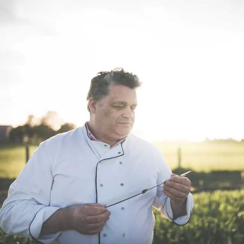 Luc David bekijkt graanhalmen in zijn veld